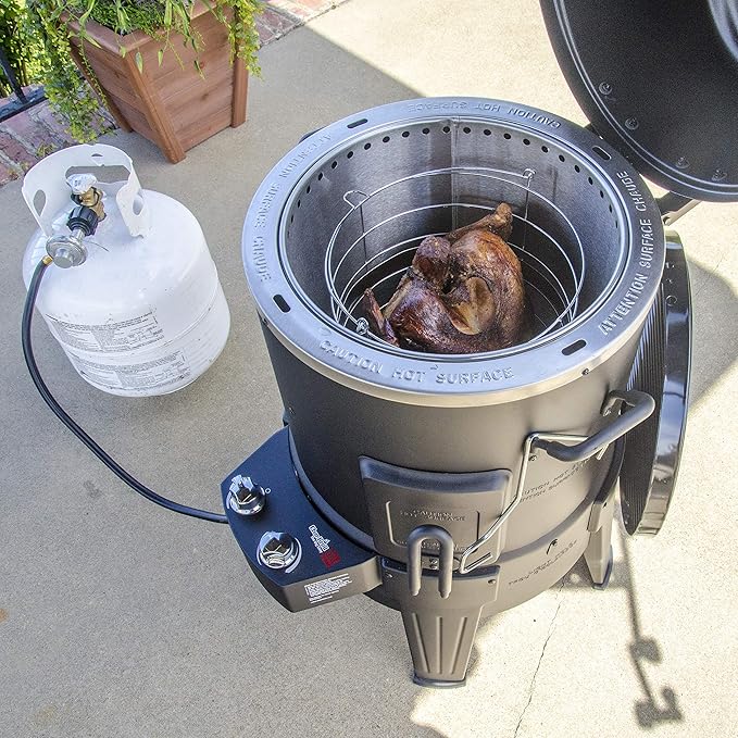 Portable barbecue grill with a chicken inside on a concrete surface.